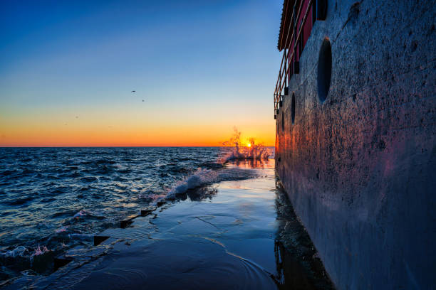 Water Waves Crashing and Breaking Along Lighthouse Jetty - Scenic view at sunset over Lake Michigan, USA.
