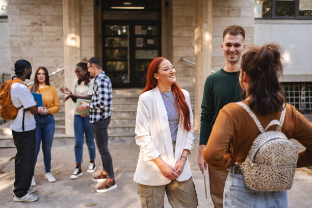 istock Students engaged in lively discussions outside their university building on a sunny afternoon, showcasing camaraderie and diverse perspectives 2181752598
