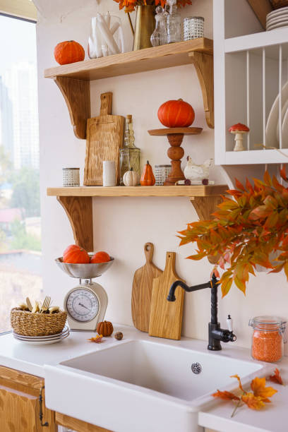 istock Autumn kitchen decor with pumpkins, cutting boards, and vibrant foliage in a bright space 2181753471