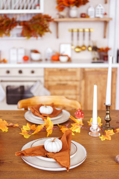 istock Dining table decorated with pumpkins and fall foliage in a cozy kitchen setting for autumn holiday 2181753483