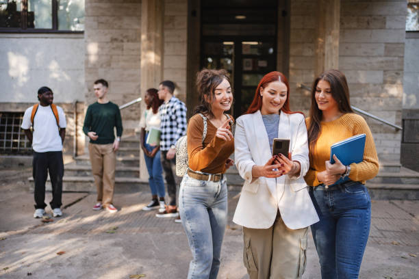 istock Students enjoy a sunny day outside the university, sharing a moment of discovery while reviewing content on a mobile device together 2181753627