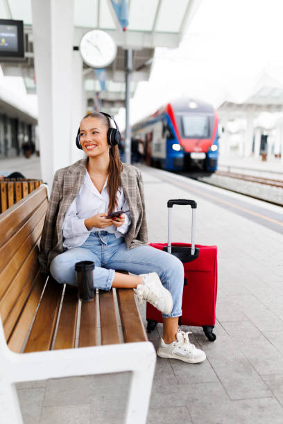 istock Female passenger using phone at train station. Travel and active lifestyle concept. Travel by train station 2181753637