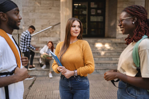 istock Students engage in lively conversation outside a university building on a sunny afternoon, fostering connections and friendships 2181753681