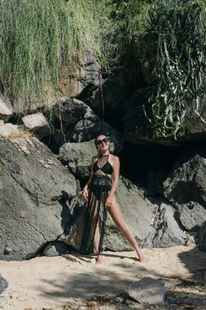 istock A model confidently poses on the sandy beach, showcasing a striking black outfit 2181753932