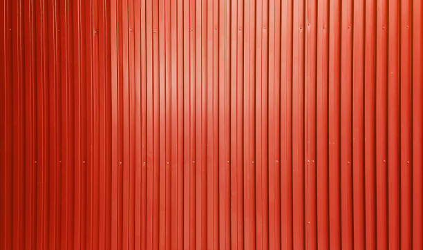 real chrome light red corrugated metal sheet wall showing vertical pattern, bolts, screw. modern industrial red metal sheet wall facade. real chrome light red corrugated metal sheet wall showing vertical pattern, bolts, screw. modern industrial red metal sheet wall facade. wide surface of red aluminum wall texture use for design. corrugated metal fence ideas stock pictures, royalty-free photos & images