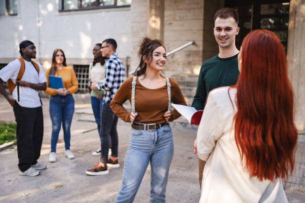 istock Students engage in lively discussions outside their university building while enjoying a sunny afternoon 2181754306