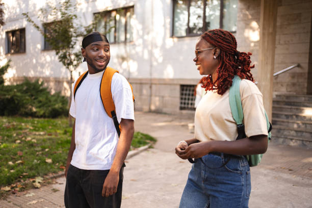 istock Two students enjoy a lively conversation on a sunny afternoon while walking across campus, surrounded by greenery and buildings 2181754495