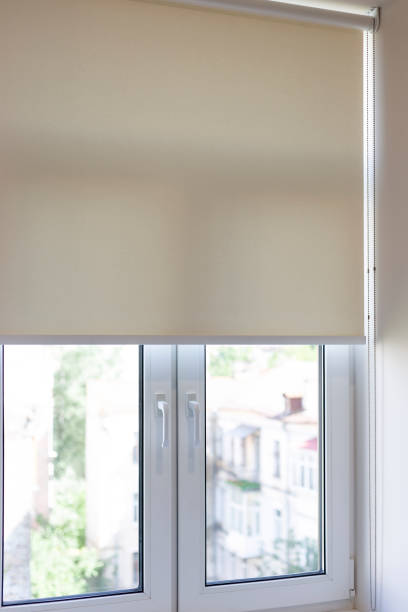 istock Window roller blind is pulled down, blocking the view of the city outside 2181757456