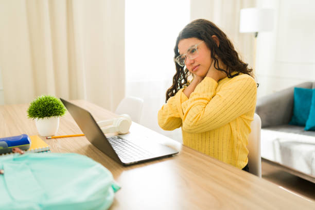 Health issues arising from prolonged screen time: a young student experiences neck stiffness while using a laptop for homeschooling
