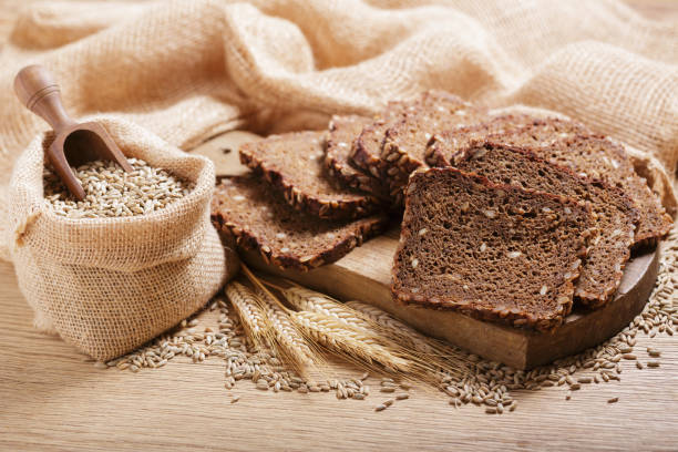 istock fresh bread, rye grains and spikelets on wooden table 2181759092