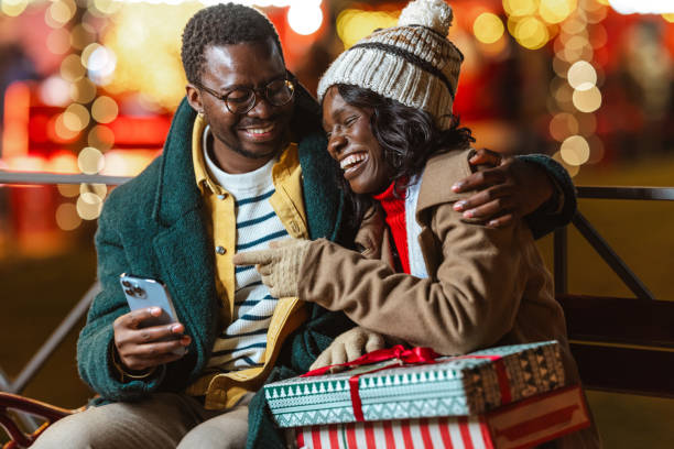 istock Couple enjoying a festive Christmastime evening outdoors and using a smartphone 2181760756