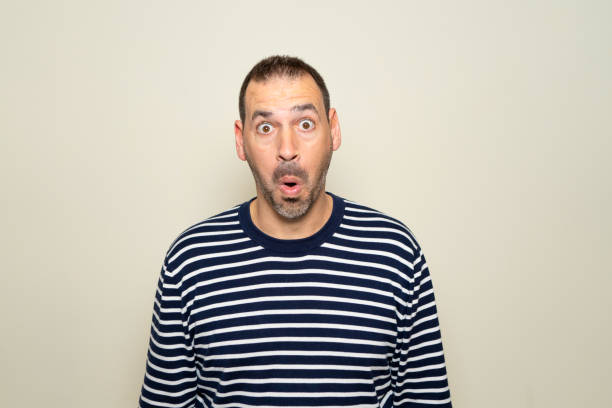 istock Hispanic man with beard about 40s scared and shocked with surprise expression, fear and excited face. Isolated on beige background. 2181765943