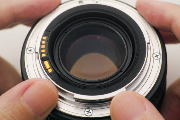istock A man holding an old camera lens with dust on it in his hands 2181766719