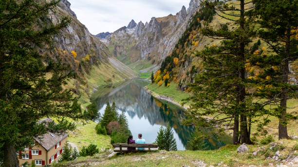 A couple enjoys a tranquil moment together, surrounded by the vibrant autumn colors of Falensee in Appenzell, Switzerland.