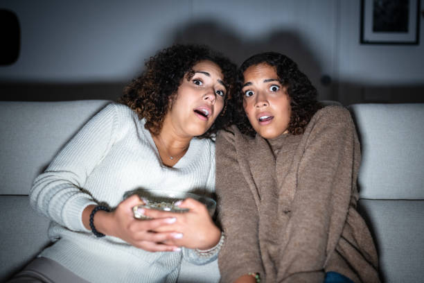istock Sisters watching TV on sofa: Scary movie 2181768040