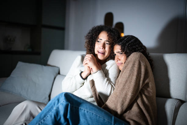 istock Sisters watching TV on sofa: Scary movie 2181768182