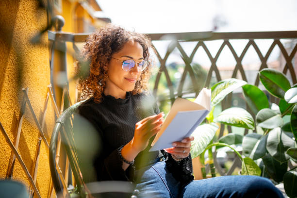 Woman reading book on the balcony