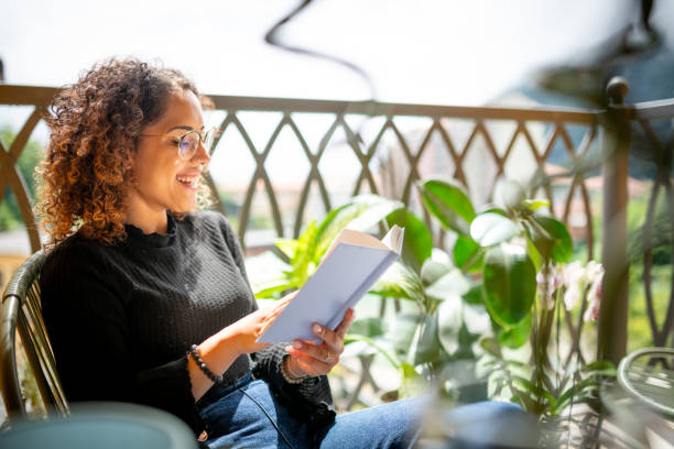 istock Woman reading book on the balcony 2181768469