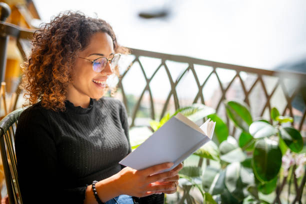 istock Woman reading book on the balcony 2181768485