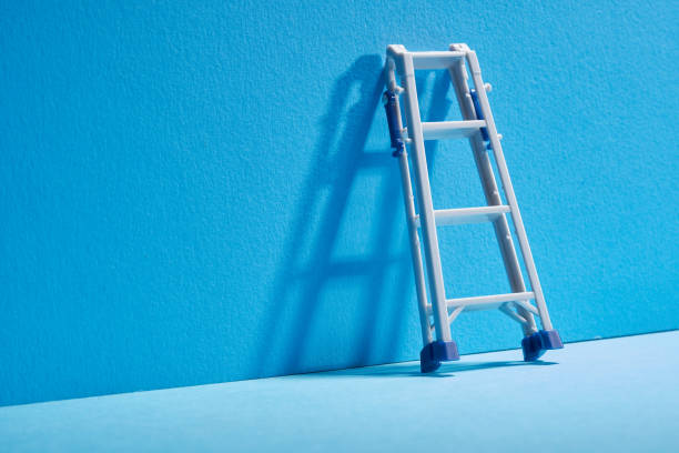 Blue wall with  small toy  folding ladder