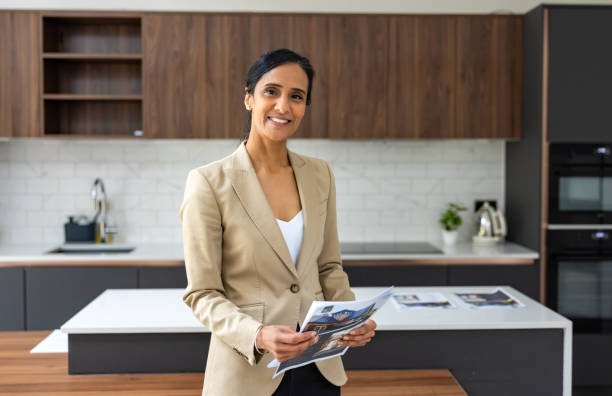 istock Real estate agent holding brochures at an open house 2181769380