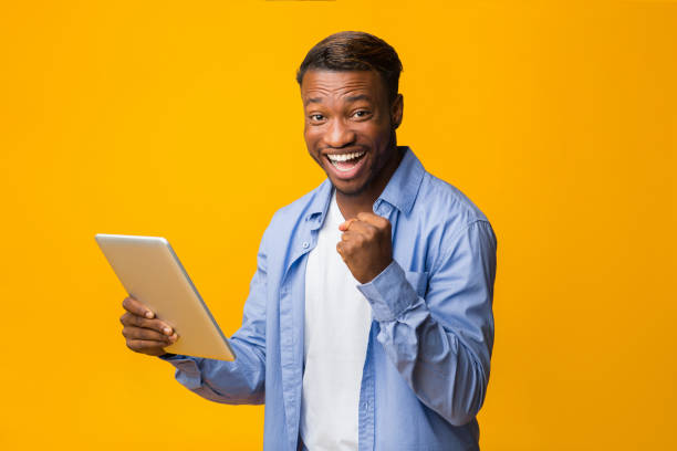 istock Cheerful African American Guy Holding Tablet Gesturing Yes, Studio Shot 2181773702