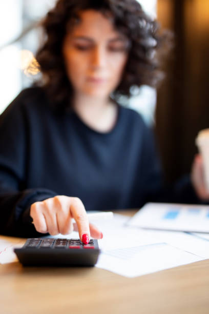 istock Woman at desk in office using calculator 2181776314
