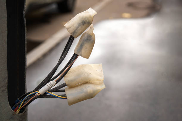 metal posts with wires covered by silicone caps, showcasing a practical approach to waterproofing in electrical installations, ensuring safety and longevity