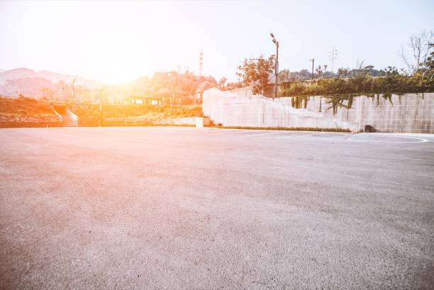 istock Empty parking lot with a brick wall and trees in the background 2181780621
