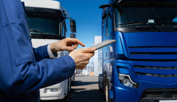 istock Fleet manager with digital tablet on a background of trucks. 2181781020