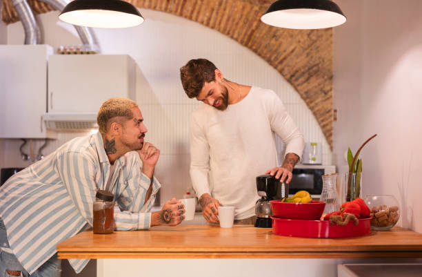istock Gay couple making coffee and smiling in kitchen 2181782706