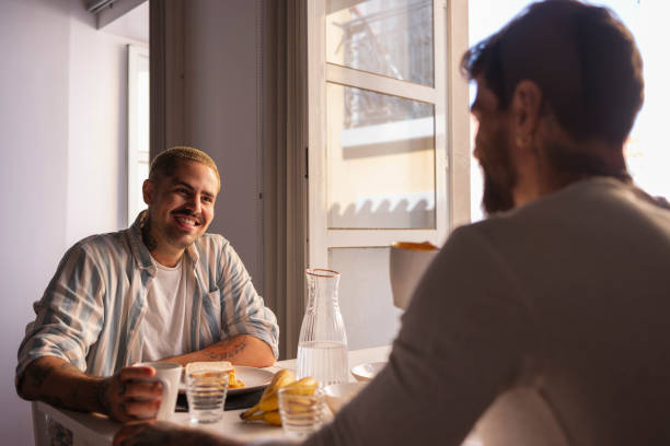 istock Gay couple enjoying breakfast and talking at home 2181782765