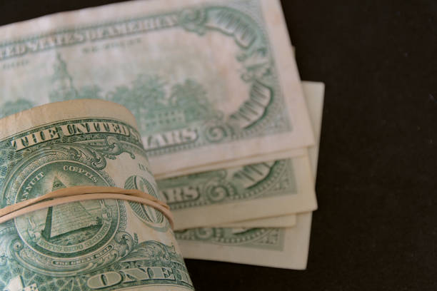 istock Hundred dollar bills and roll of one dollar bills 2181783670