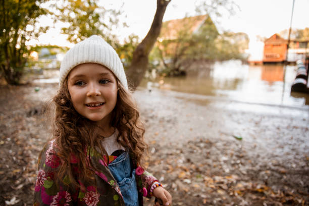 Child Girl walking over mud on the river waterfront . Copy space