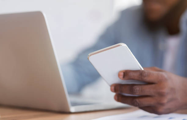 istock Unrecognizable black entrepreneur using smartphone and working on laptop 2181789559