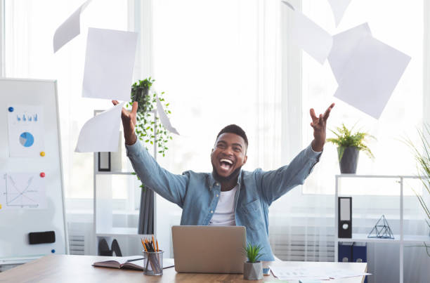 istock Joyful Black Businessman Throwing Papers In The Air At Workplace 2181789653