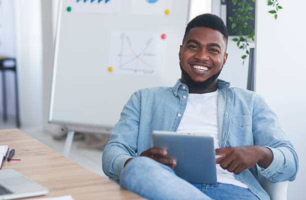 istock Cheerful business coach holding digital tab, sitting in modern office 2181789681