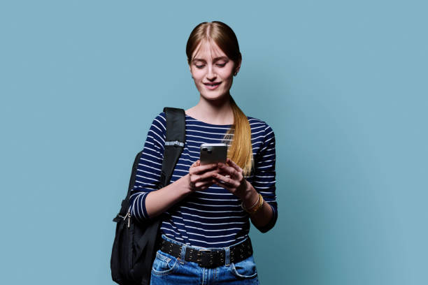 istock Young beautiful woman using smartphone on blue studio background 2181794779