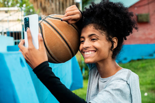 istock Young basketball player woman using mobile phone outdoors 2181794792