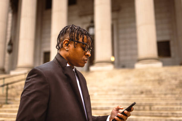 istock Black businessman in suit using smartphone outside courthouse 2181796787