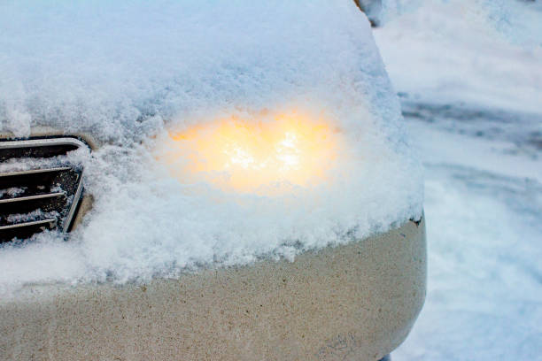 glowing head light car headlights through a layer of snow fell from the sky