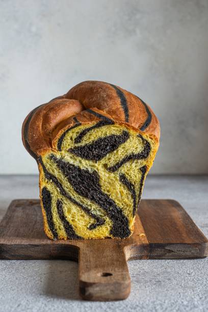 istock Unusual pumpkin marbled (tiger print) bread with cuttlefish ink, braided on a light background. Useful home baking. Texture laid out from slices of bread. 2181799098