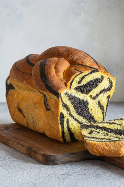 Unusual pumpkin marbled (tiger print) bread with cuttlefish ink, braided on a light background. Useful home baking. Texture laid out from slices of bread.