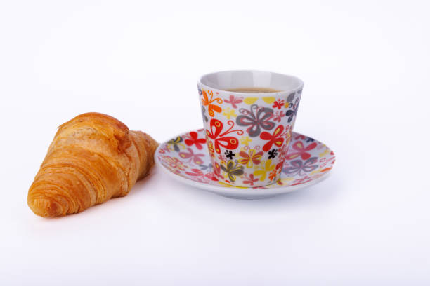 A simple yet elegant breakfast featuring croissants and coffee on a light marble table. The scene highlights a peaceful morning atmosphere in detail