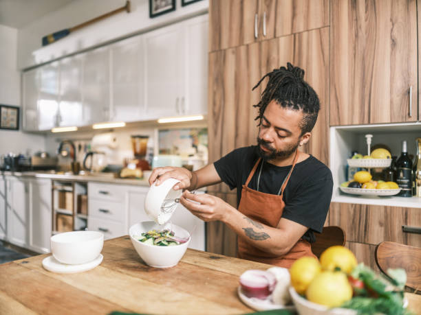 istock Young Mixed race man preparing salad in home kitchen 2181800325