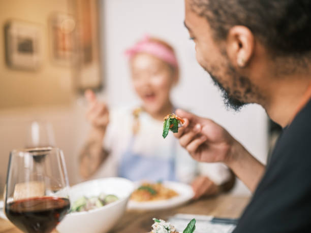 istock Young Mixed race couple enjoying pasta dish in home kitchen 2181800438