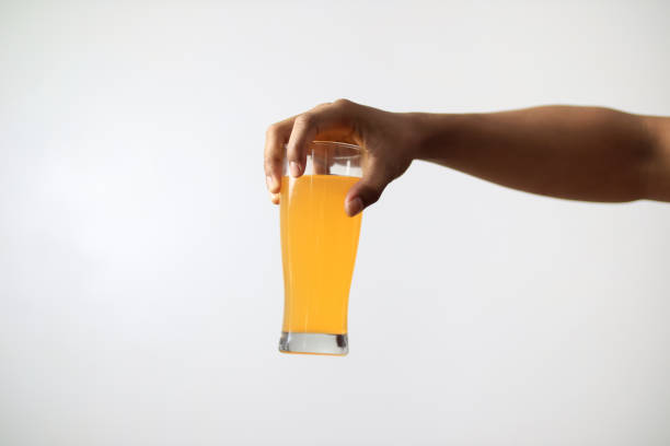 istock hand holding orange juice on white background 2181801276