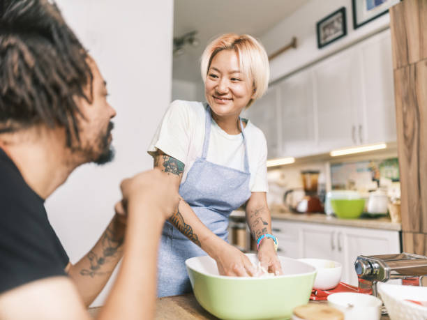 istock Young Mixed race couple preparing pasta dish in home kitchen 2181802101