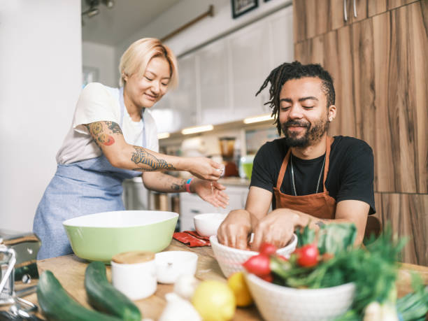 istock Young Mixed race couple preparing pasta dish in home kitchen 2181802140