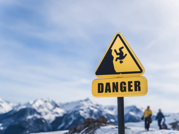 Danger sign in snowy mountain area warning of steep cliffs
